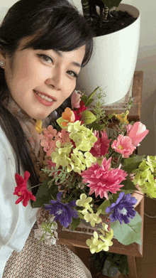 a woman holds a bouquet of flowers in front of her face