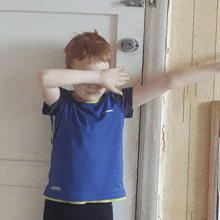 a young boy wearing a blue shirt that says asics