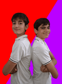 two boys standing back to back with their arms crossed on a red and purple background