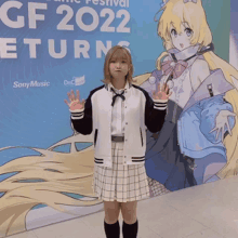 a girl stands in front of a gf 2022 sign