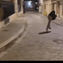 a blurred image of a person walking down a cobblestone street