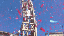 confetti is being thrown from a tower that has the letter x on it