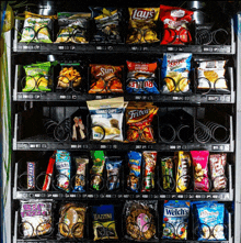 a vending machine filled with various snacks including lays and fritos