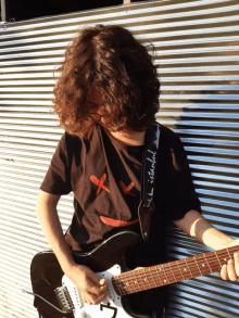 a person playing a guitar with the word istanbul on their shirt