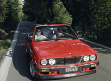 a red bmw with a license plate that says r41523-mt