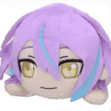 a stuffed animal with purple hair and yellow eyes is laying down on a white surface .