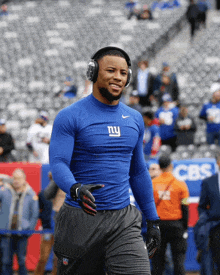 a man wearing headphones and a blue ny jersey