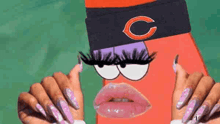 a woman is holding a spongebob squarepants character with long nails and a hat on .