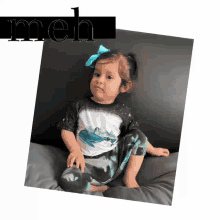 a little girl wearing a shirt with a whale on it sits on a couch