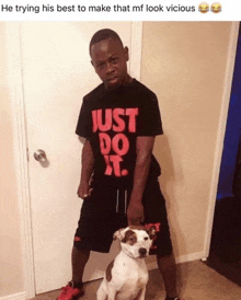 a man wearing a just do it shirt holds a dog