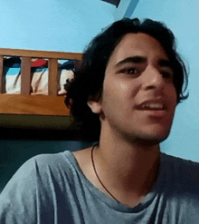 a young man with long hair is making a face in front of a bunk bed .