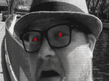 a man wearing glasses and a hat has a red circle in his eye