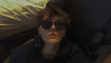 a person wearing sunglasses and headphones is laying down