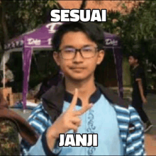 a young man wearing glasses and a backpack is making a peace sign .