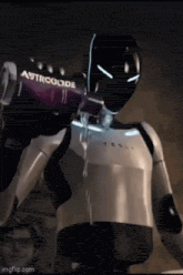 a robot is pouring a drink from a bottle into his mouth .