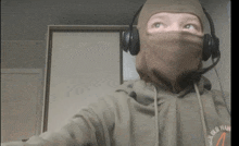 a person wearing a mask and headphones has a hoodie that says ' old man ' on the front