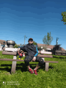 a man is sitting on a bench with a redmi note 8t camera