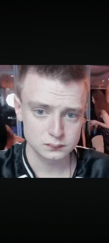 a close up of a young man 's face with blue eyes