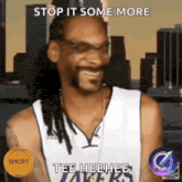 snoop dogg is wearing a lakers jersey and smiling .