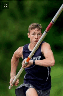 a man wearing a vest that says east is running with a pole