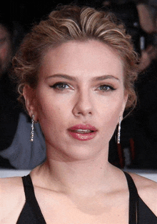 a close up of a woman 's face with earrings on