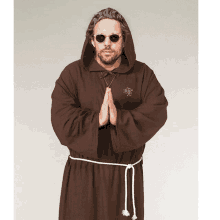 a man wearing a brown robe with a hood and sunglasses