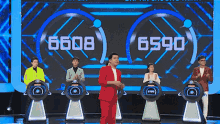 a man in a red suit is standing in front of a screen that says 6698