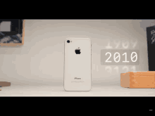 a white iphone is sitting on a table next to a box