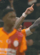a blurred image of a man wearing an orange shirt