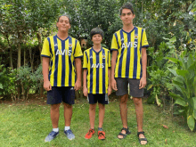 three boys wearing yellow striped shirts with avis on them