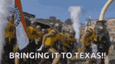 a group of football players are running on a field with the words `` bringing it to texas '' written on the bottom .