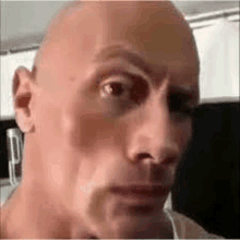 a close up of a man 's face with a bald head making a funny face .