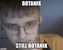 a young man wearing glasses and ear buds with the words botanik still botanik written on his face