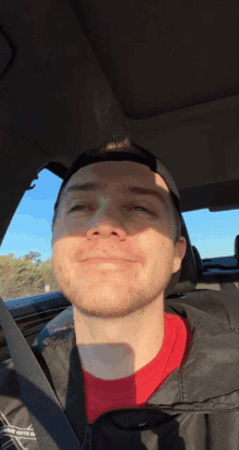 a man in a car wearing a black jacket that says eagles on it