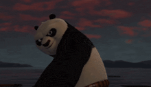 a panda bear is holding a flaming object in its paws .