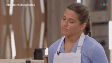 a woman in a blue shirt and white apron is on a television show called master chef argentina