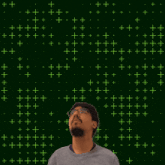 a man with glasses stands in front of a green background with the number 18 on it