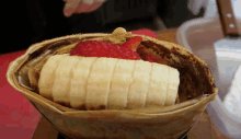 a crepe with a banana and strawberries on top