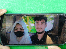 a man and a woman wearing face masks are shown on a phone screen