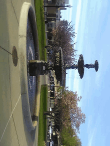 a fountain in a park has a statue of a man on top