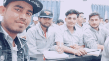 a man wearing a new york hat sits in a classroom with other men