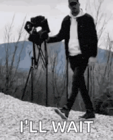 a man is walking down a hill with a camera in his hand .