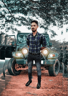 a man in a plaid shirt stands next to a jeep