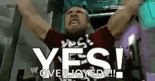a man is raising his arms in the air and saying yes overjoyed .