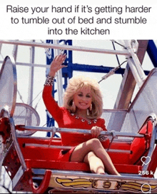 dolly parton is sitting on a roller coaster and waving at the camera