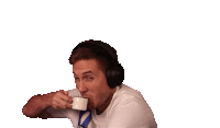 a man wearing headphones is drinking from a mug