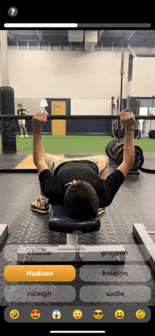 a man is lifting a barbell in a gym with the name hudson on the bottom