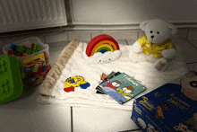 a teddy bear sits on a blanket next to a box of puzzle create