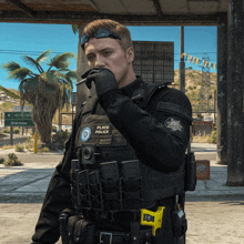 a police officer is smoking a cigarette while wearing a black vest that says police on it