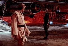 two men in star wars costumes are standing next to each other in front of a red background .